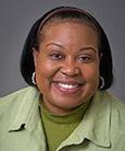 woman in a green shirt smiling at the camera