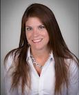 Headshot: dark haired woman in a white button down shirt smiling at the camera